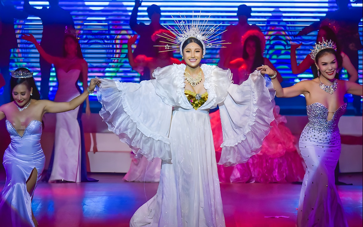 Performers in elaborate costumes on stage at the Golden Dome Cabaret Show.