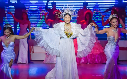 Performers in elaborate costumes on stage at the Golden Dome Cabaret Show.