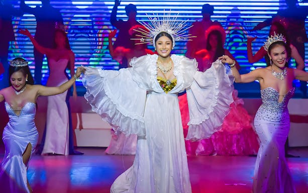 Performers in elaborate costumes on stage at the Golden Dome Cabaret Show.