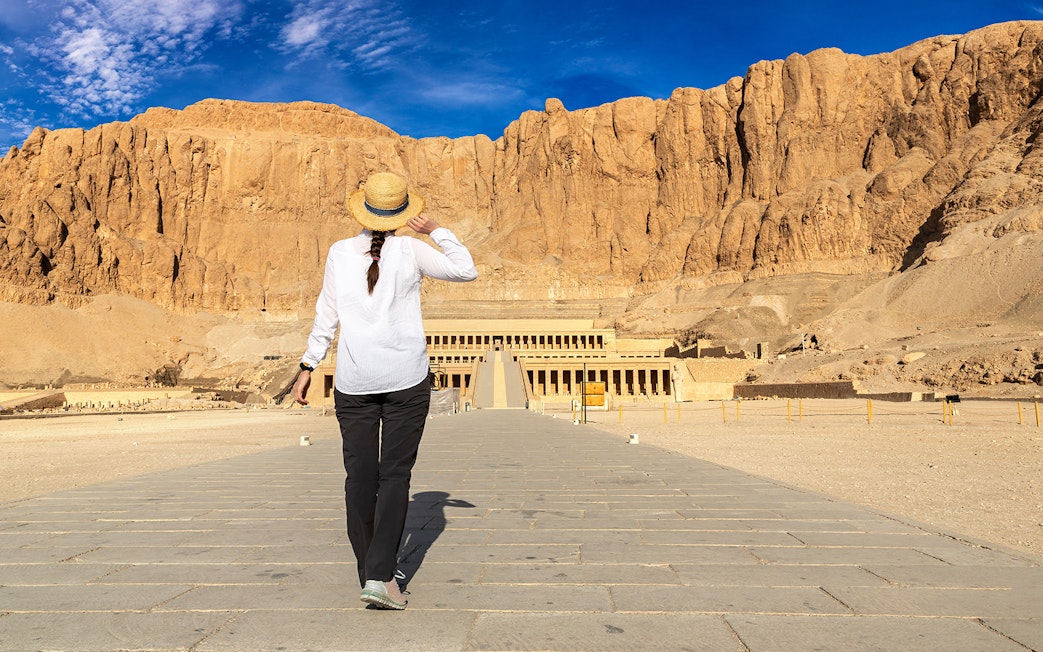 Tourist walking towards Hatshepsut Temple in Valley of the Kings, Egypt.