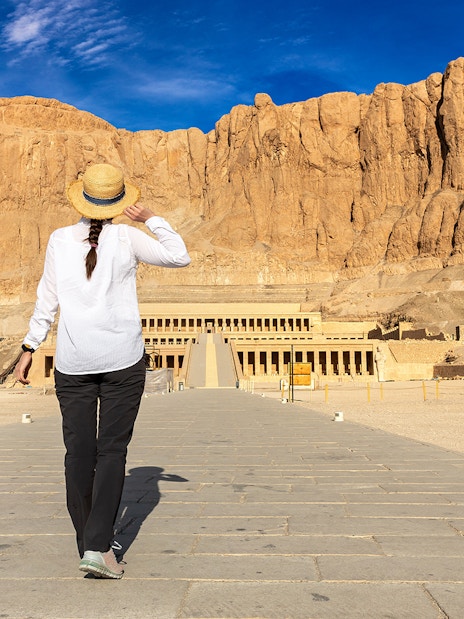 Tourist walking towards Hatshepsut Temple in Valley of the Kings, Egypt.
