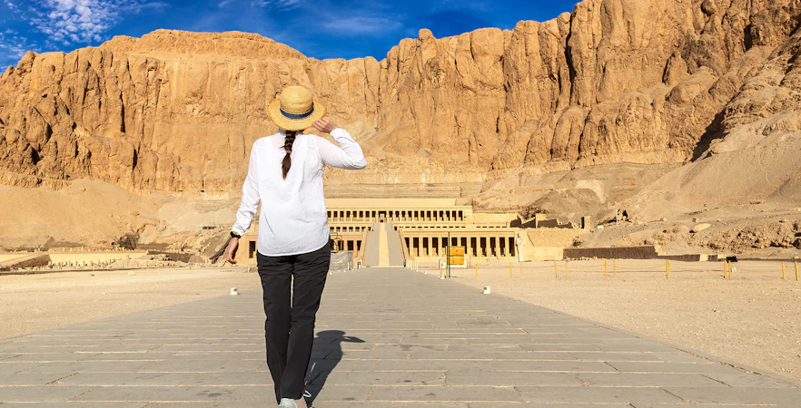 Tourist walking towards Hatshepsut Temple in Valley of the Kings, Egypt.