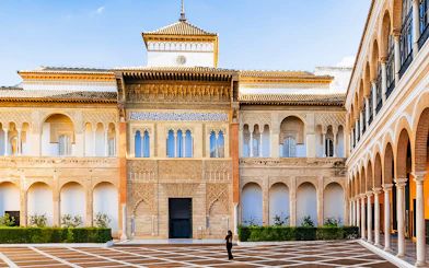 Alcazar of Seville courtyard with intricate arches and detailed facade.