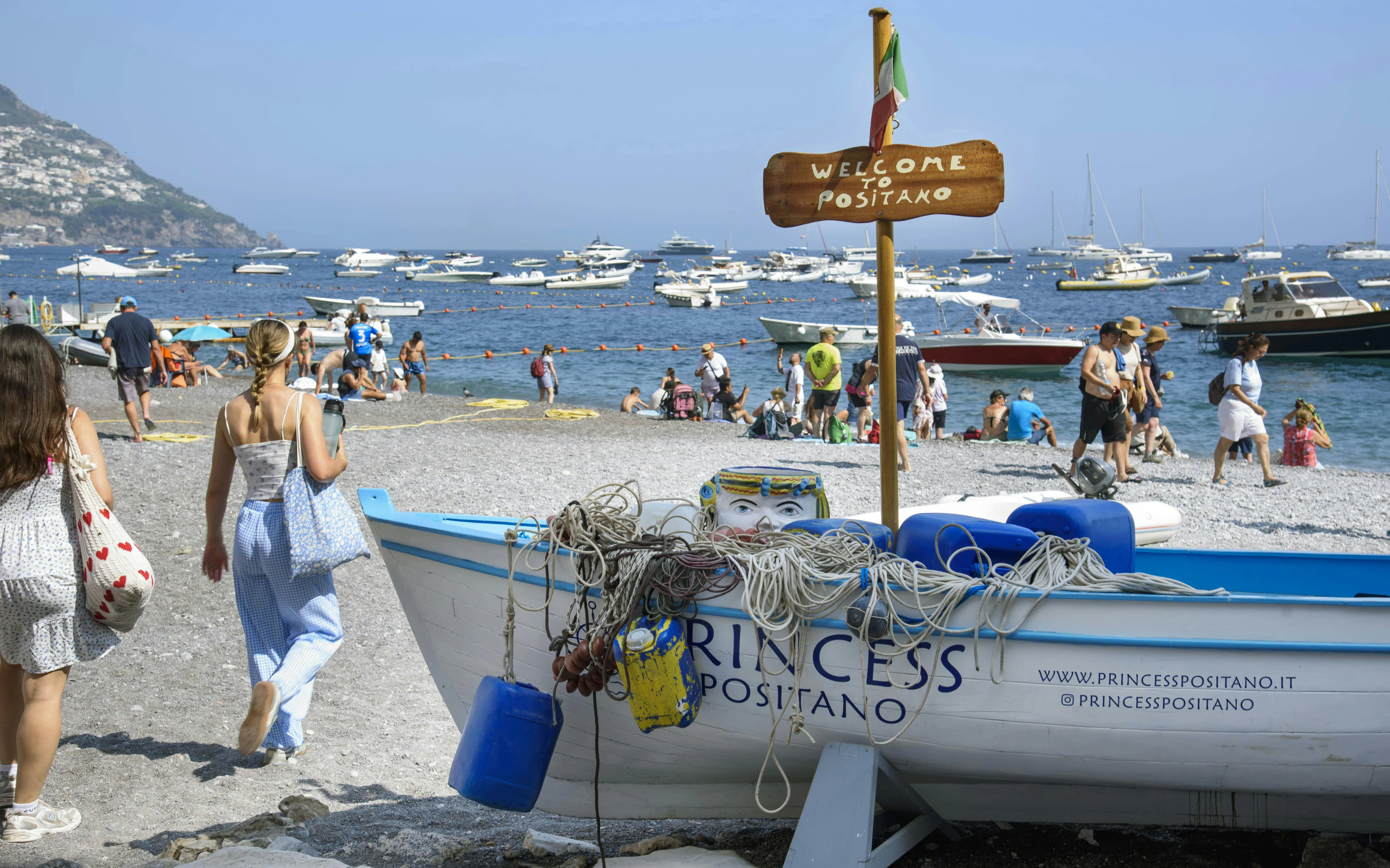 Beachgoers and boats at Positano beach, Amalfi Coast tours.