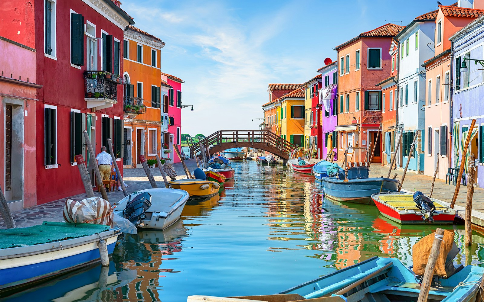 Tre Ponti Bridge over colorful canal houses on Burano Island, Venice.