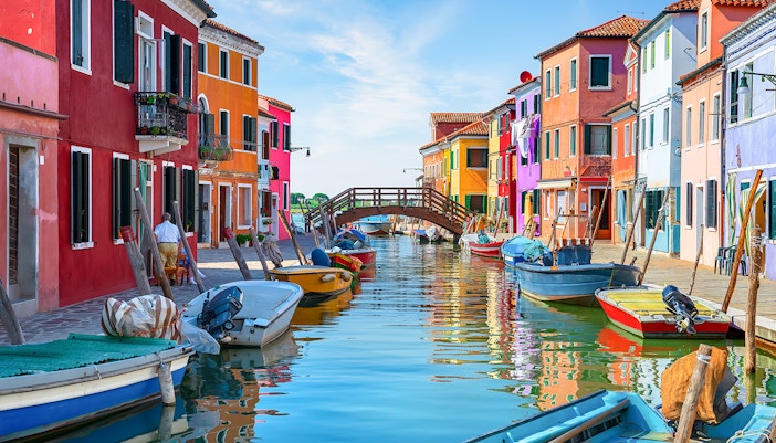 Tre Ponti Bridge over colorful canal houses on Burano Island, Venice.