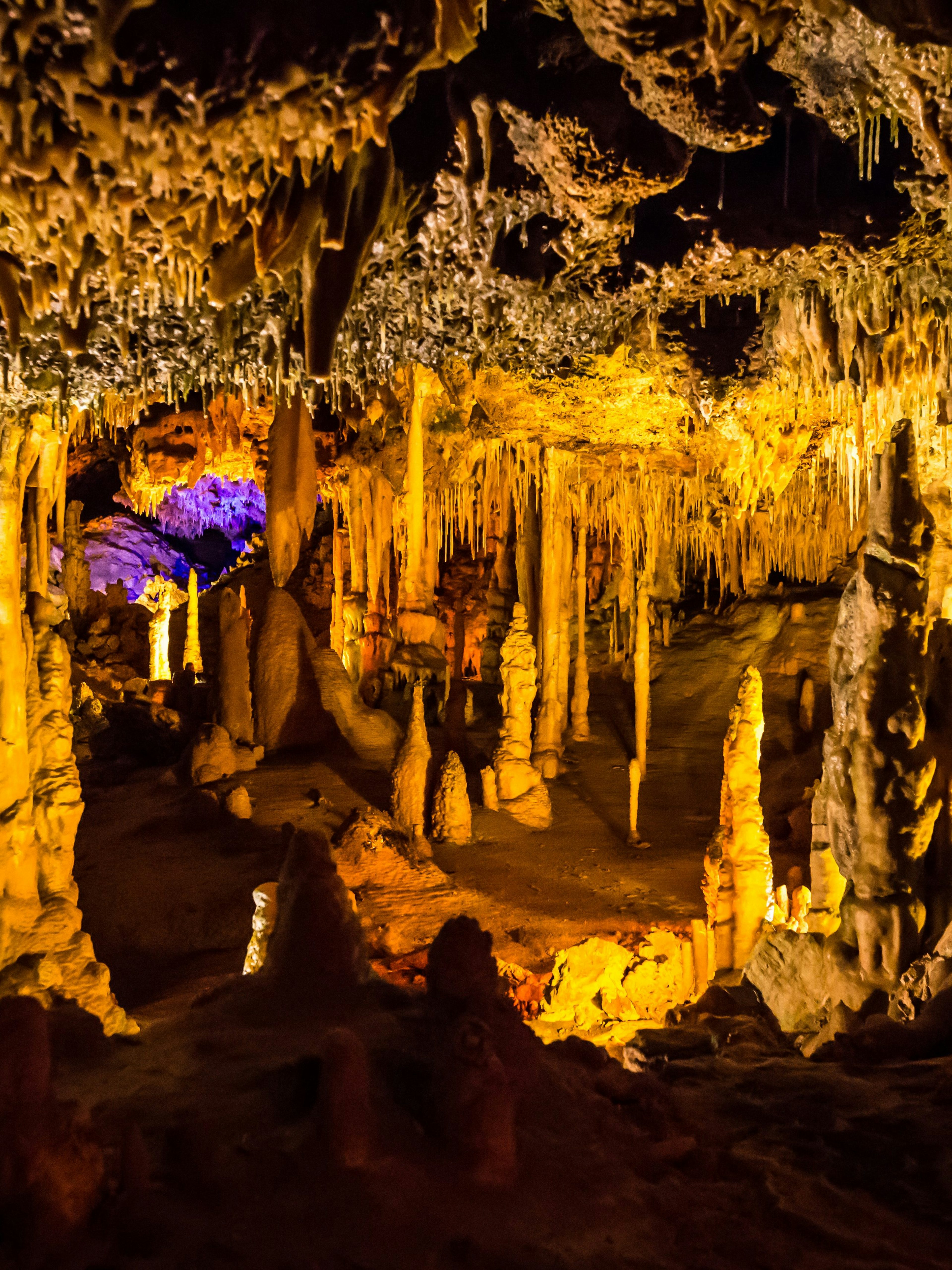 Stalactites and stalagmites in illuminated Hams Caves interior.