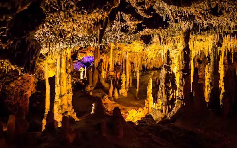 Stalactites and stalagmites in illuminated Hams Caves interior.