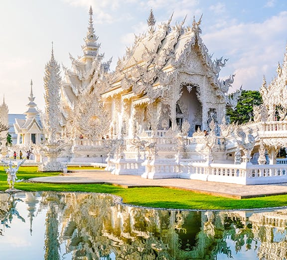 Wat Rong Khun, White Temple in Chiang Rai, Thailand, reflecting in a pond.