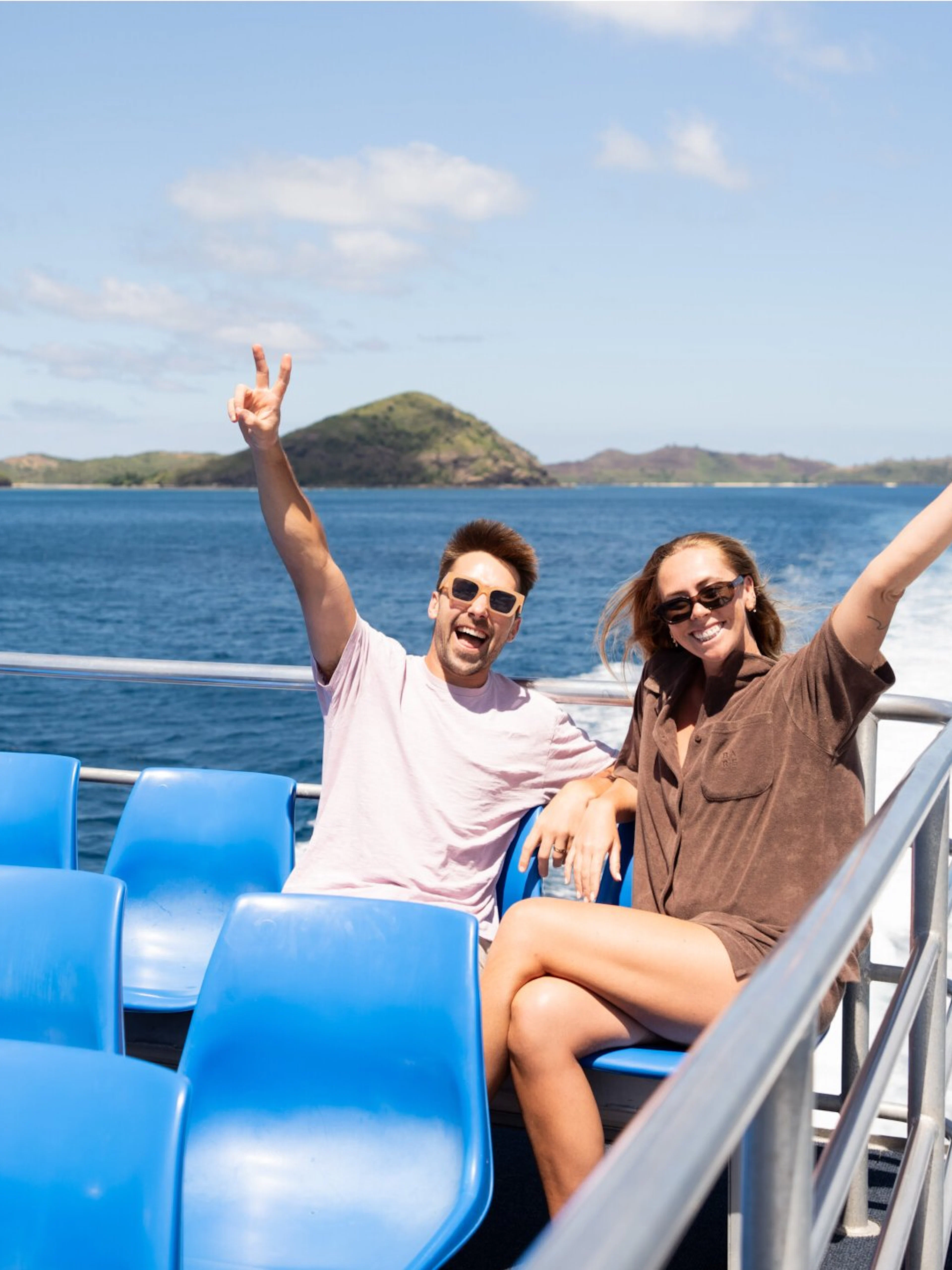 Couple enjoying cruise to Mantaray Island Resort, Fiji with ocean and islands in background.