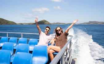 Couple enjoying cruise to Mantaray Island Resort, Fiji with ocean and islands in background.