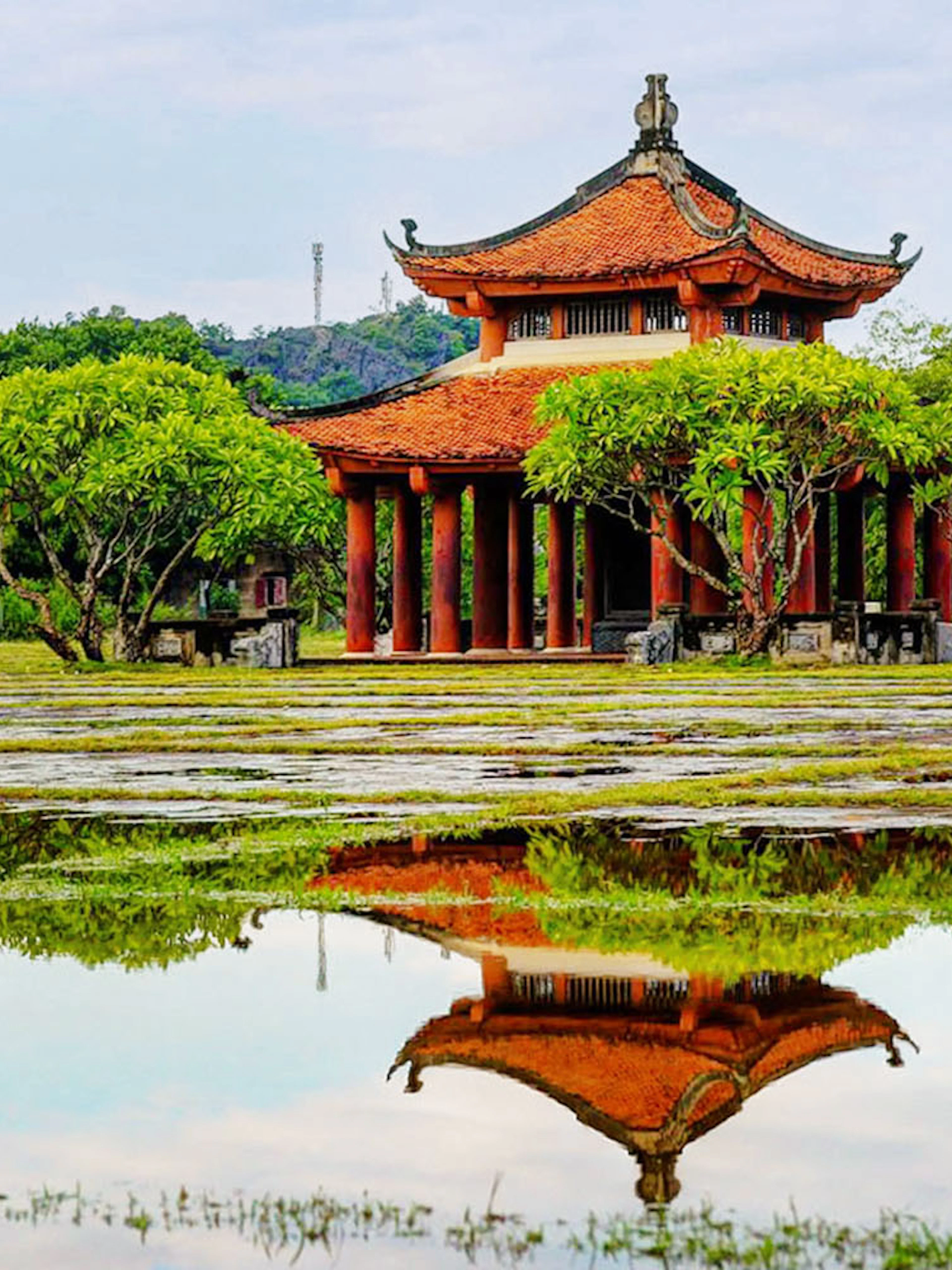 Hoa Lư Ancient Capital pavilion with red roof and columns, Ninh Bình, Vietnam.