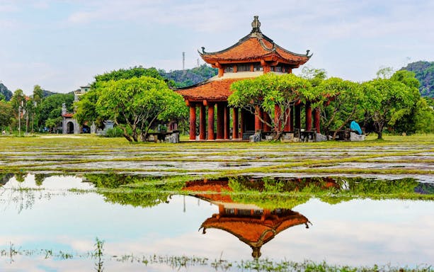 Hoa Lư Ancient Capital pavilion with red roof and columns, Ninh Bình, Vietnam.
