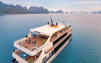 Luxury cruise ship on Ha Long Bay with scenic limestone islands in the background.