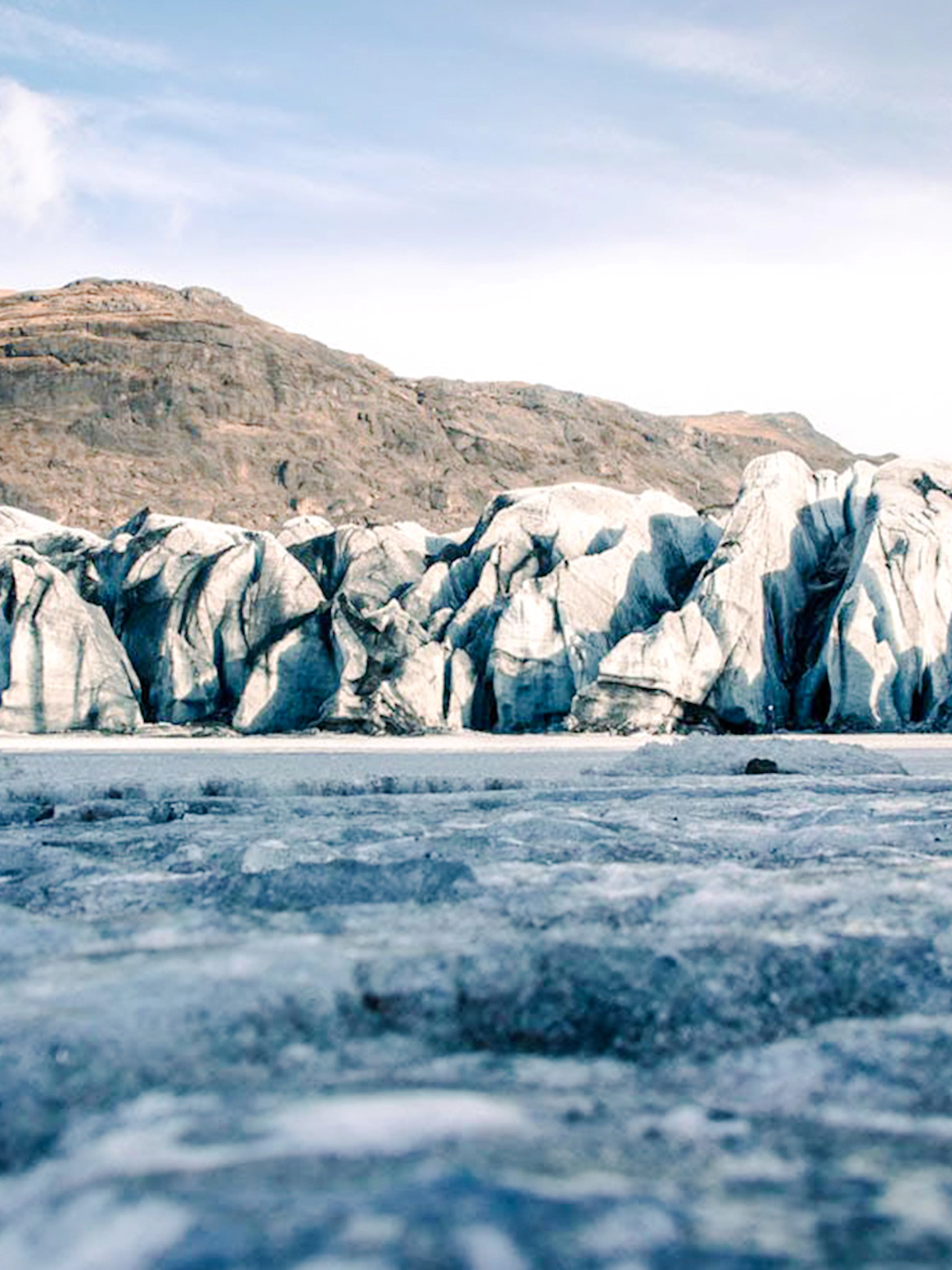 Solheimajokull glacier with rugged ice formations and distant mountain backdrop.