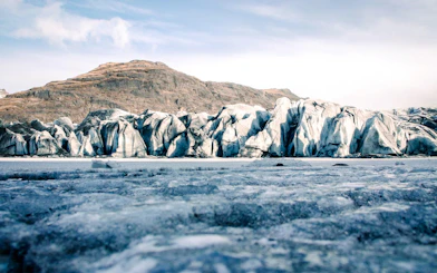 Solheimajokull glacier with rugged ice formations and distant mountain backdrop.