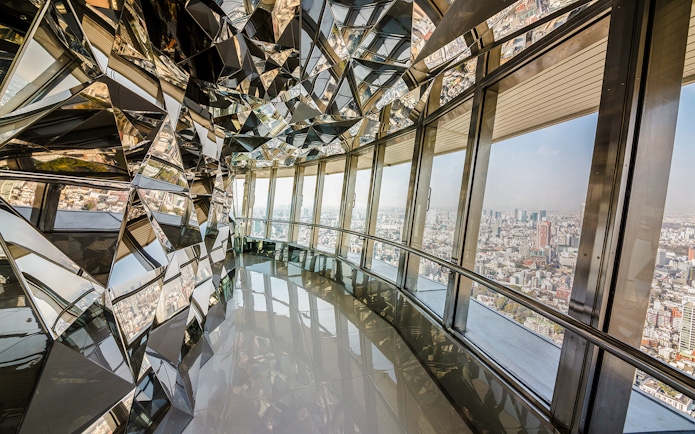 Upper deck of Tokyo Tower with mirrored walls and city view.