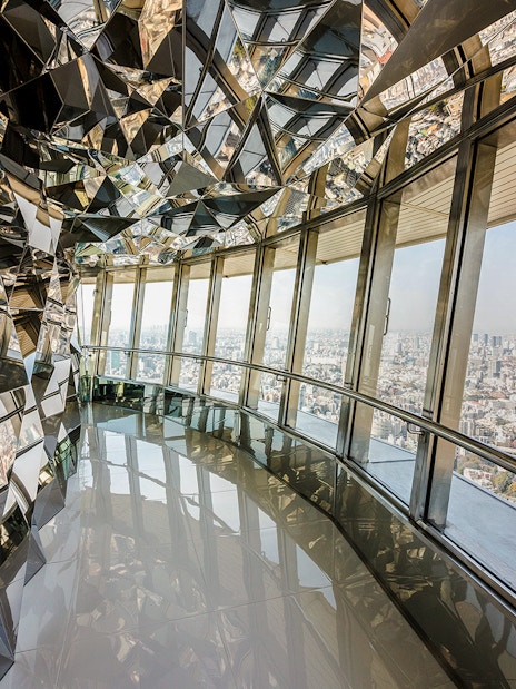 Upper deck of Tokyo Tower with mirrored walls and city view.