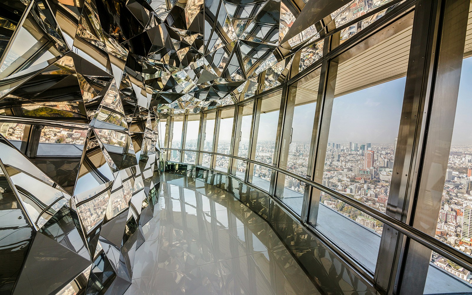 Upper deck of Tokyo Tower with mirrored walls and city view.