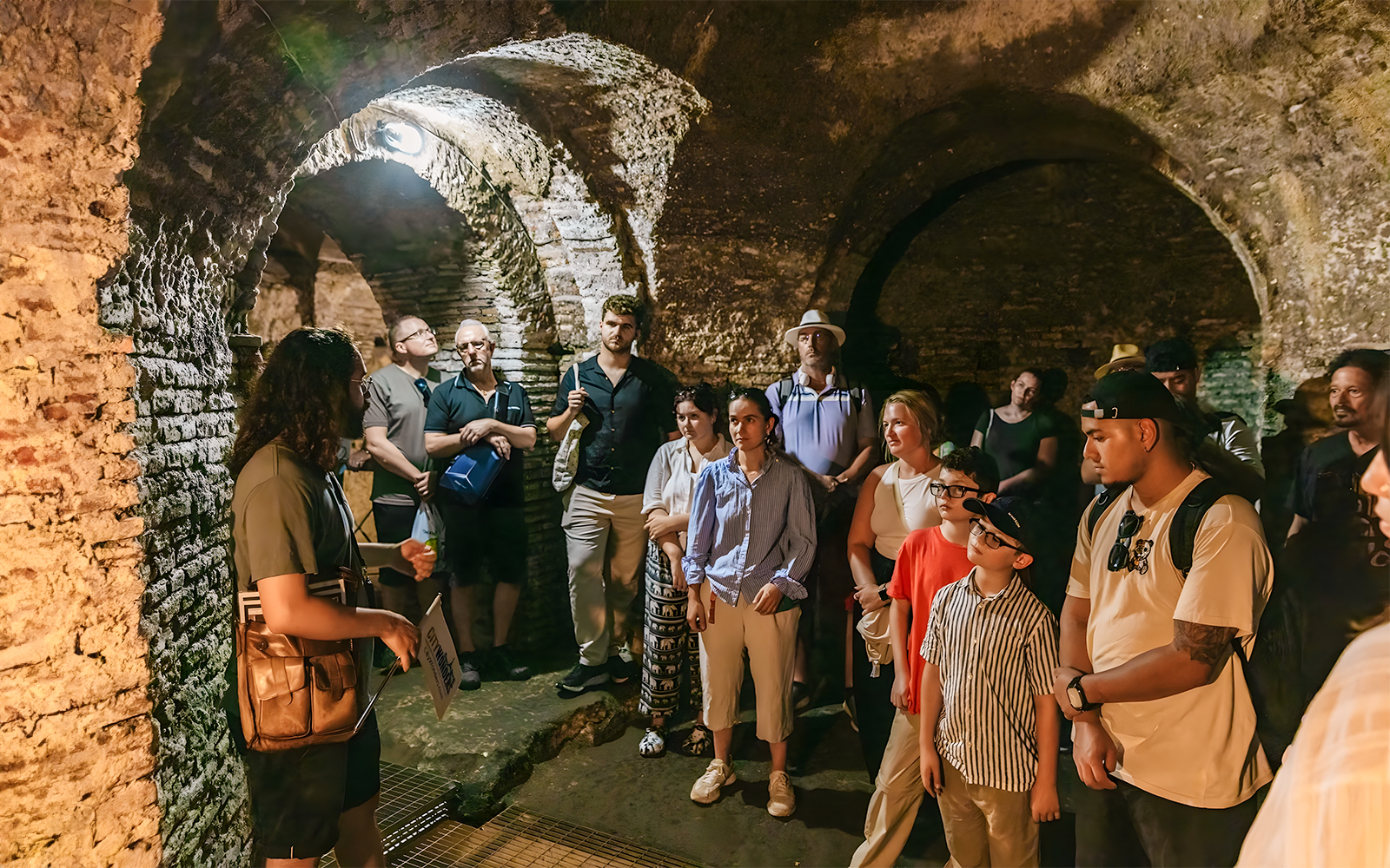 Guided tour group exploring the ancient Roman Catacombs and Basilica of San Nicola on the Appian Way in Rome, Italy