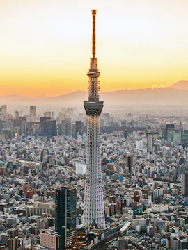 Tokyo Skytree towering over cityscape at sunset.