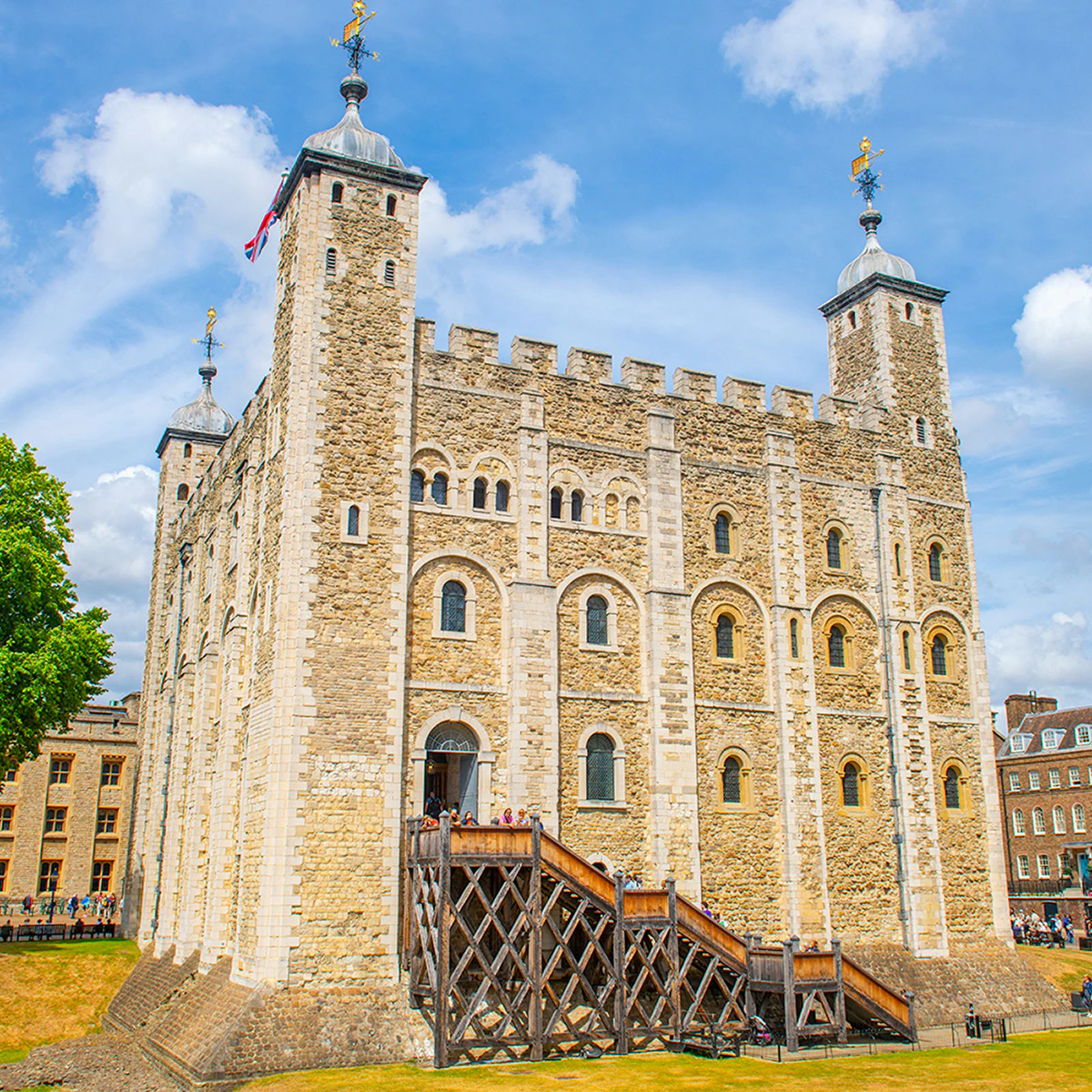 White Tower at the Tower of London with tourists exploring the historic site.