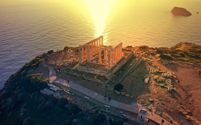 Temple of Poseidon at Cape Sounio overlooking the sea at sunset.