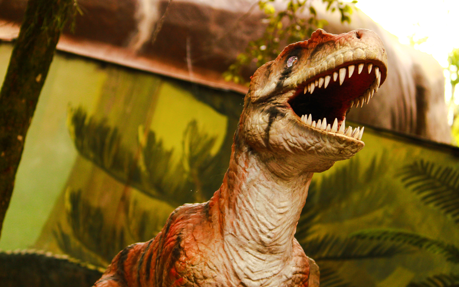 Dinosaurs in Jurassic World theme park exhibit, showcasing life-sized T-Rex and Velociraptor models.