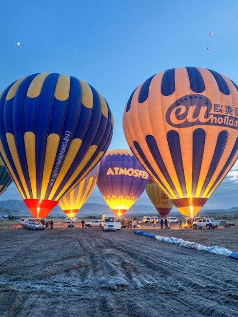 Hot air balloons preparing for flight in Gerome Valley, Cappadocia at dawn.