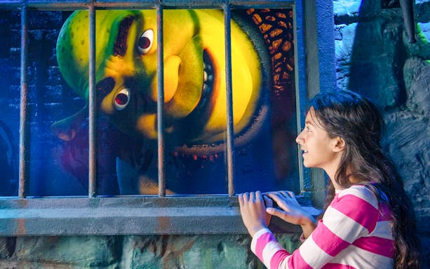 Guest interacting with Shrek at Shrek's Adventure in London.