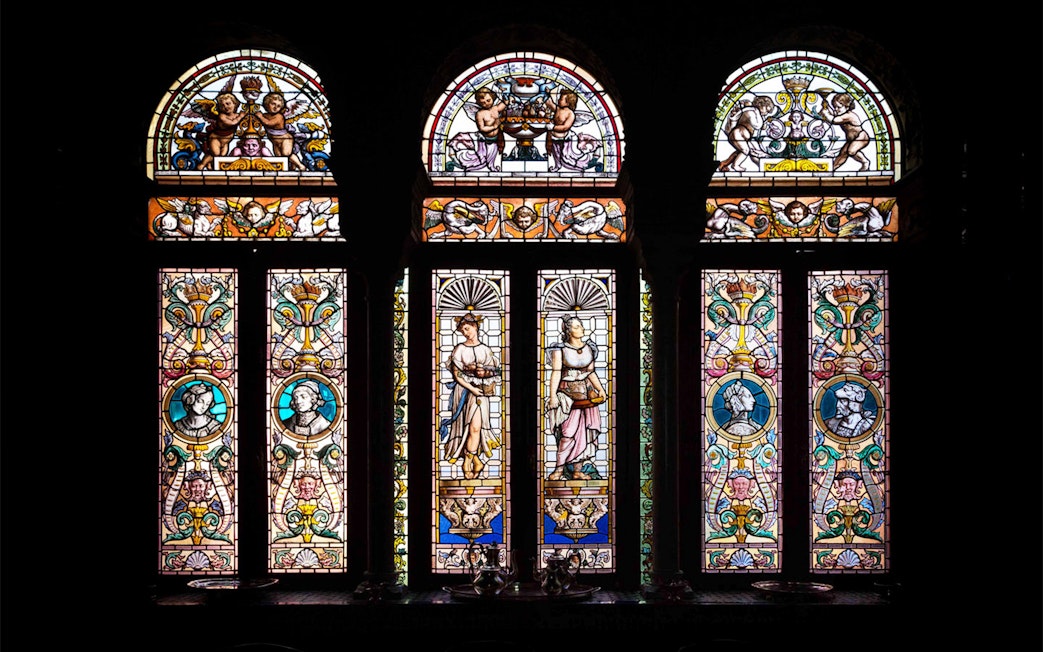 Stained glass windows depicting figures and ornate designs at Casa de Salinas.