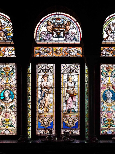 Stained glass windows depicting figures and ornate designs at Casa de Salinas.
