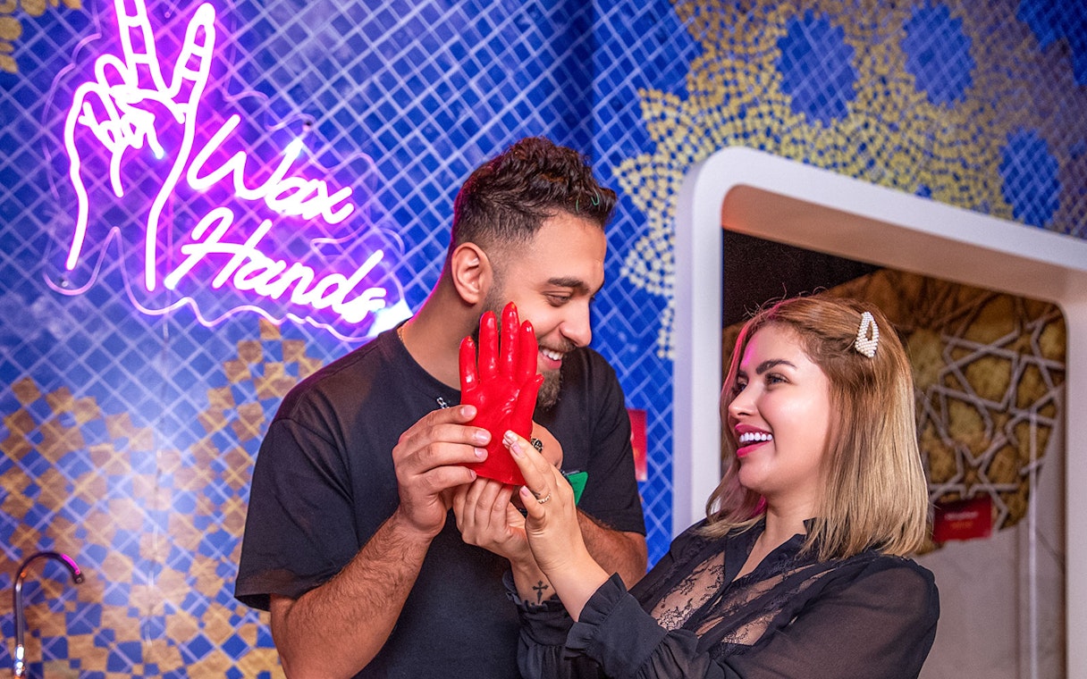 Couple creating wax hands at Madame Tussauds Dubai.