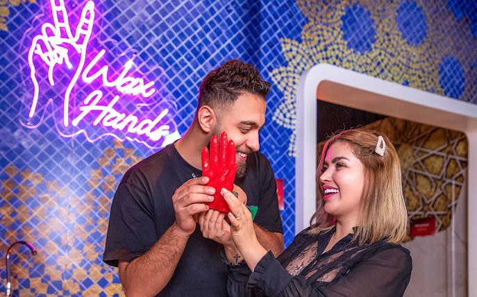 Couple creating wax hands at Madame Tussauds Dubai.