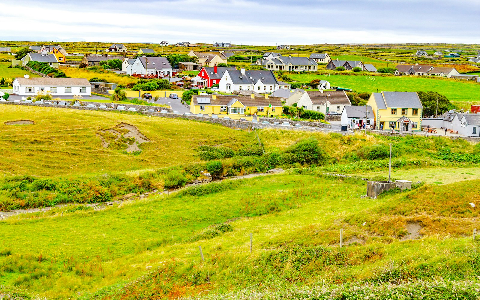 Doolin Village landscape with colorful houses and green fields in County Clare, Ireland.