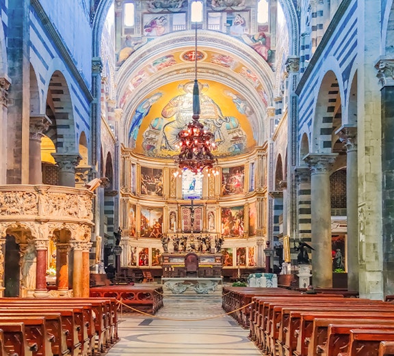Interior of Pisa Cathedral with ornate altar and frescoed dome, part of Rome to Pisa tours.