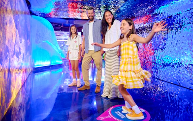 Family exploring colorful tunnel at Sea Life Melbourne.