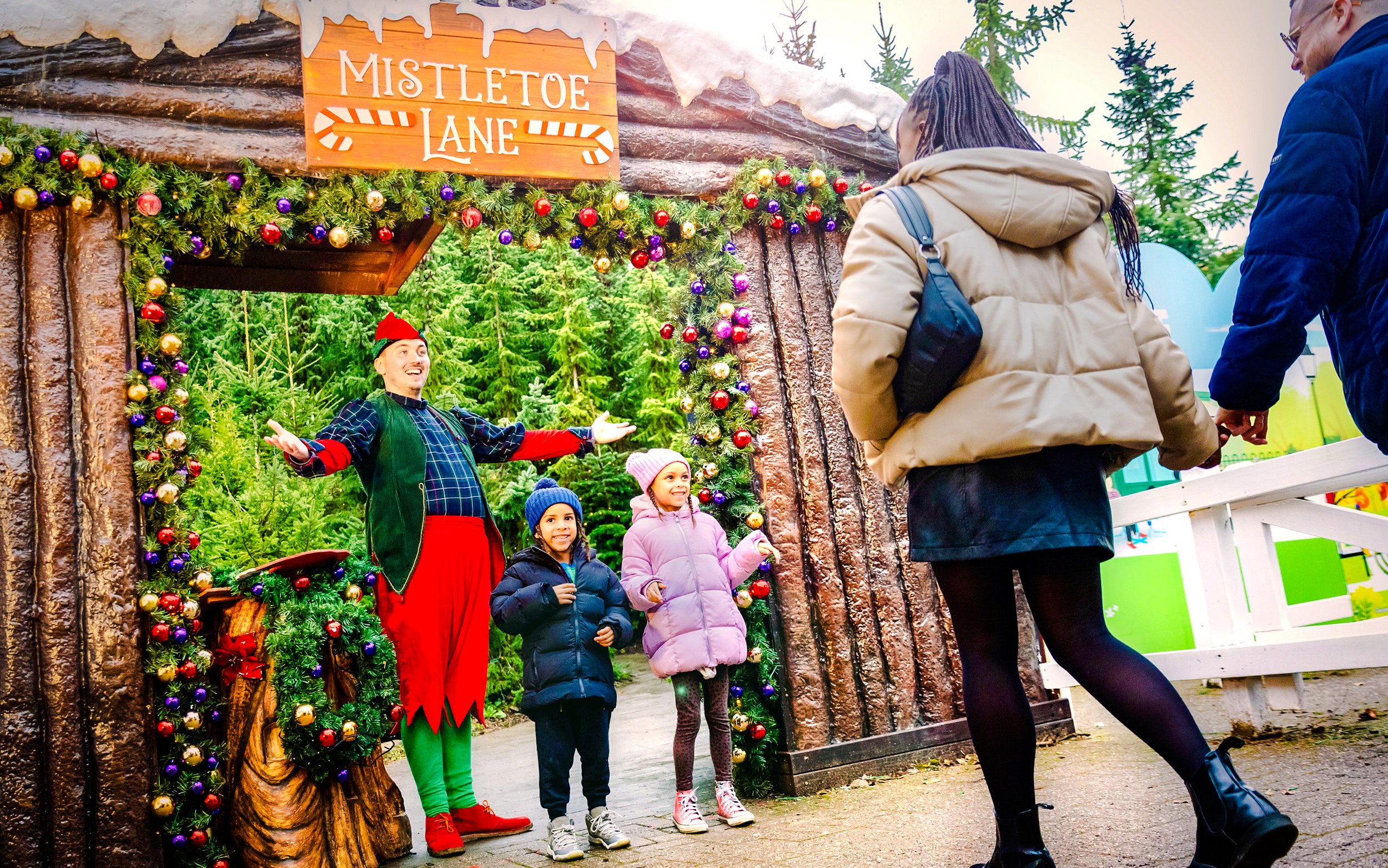 Visitors meeting an elf at Mistletoe Lane during Christmas at Alton Towers.