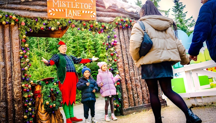 Visitors meeting an elf at Mistletoe Lane during Christmas at Alton Towers.