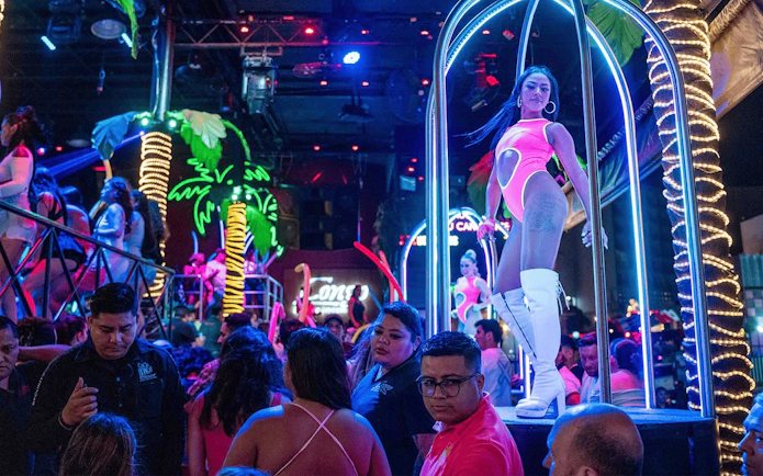 Coco Bongo Congo Bar vibrant nightlife scene with performers and neon palm trees.