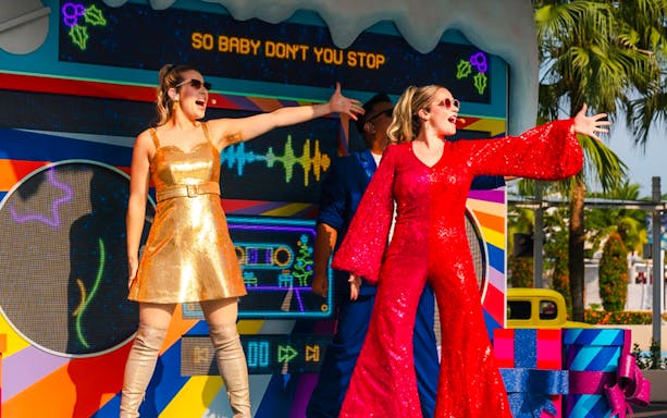 Performers in festive outfits singing at Universal Studios Singapore Christmas event.