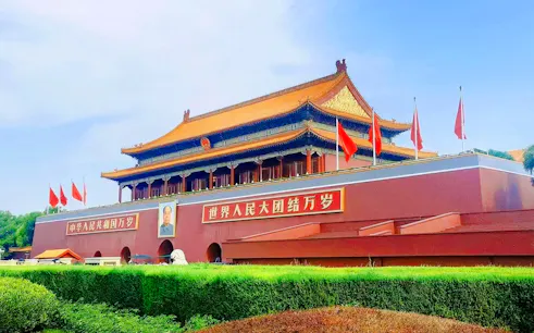 Tiananmen Gate in Beijing, China, with red flags and Mao Zedong portrait.