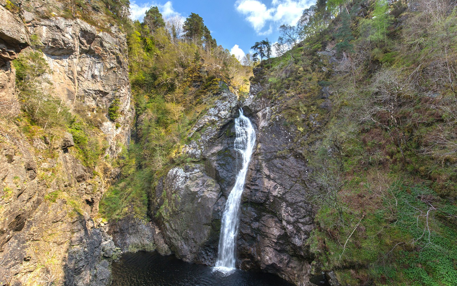 Waterfall cascading down rocky cliffs at The Falls of Foyers, Scotland.