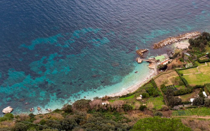 Aerial view of Capri coastline with turquoise waters and rocky shoreline.