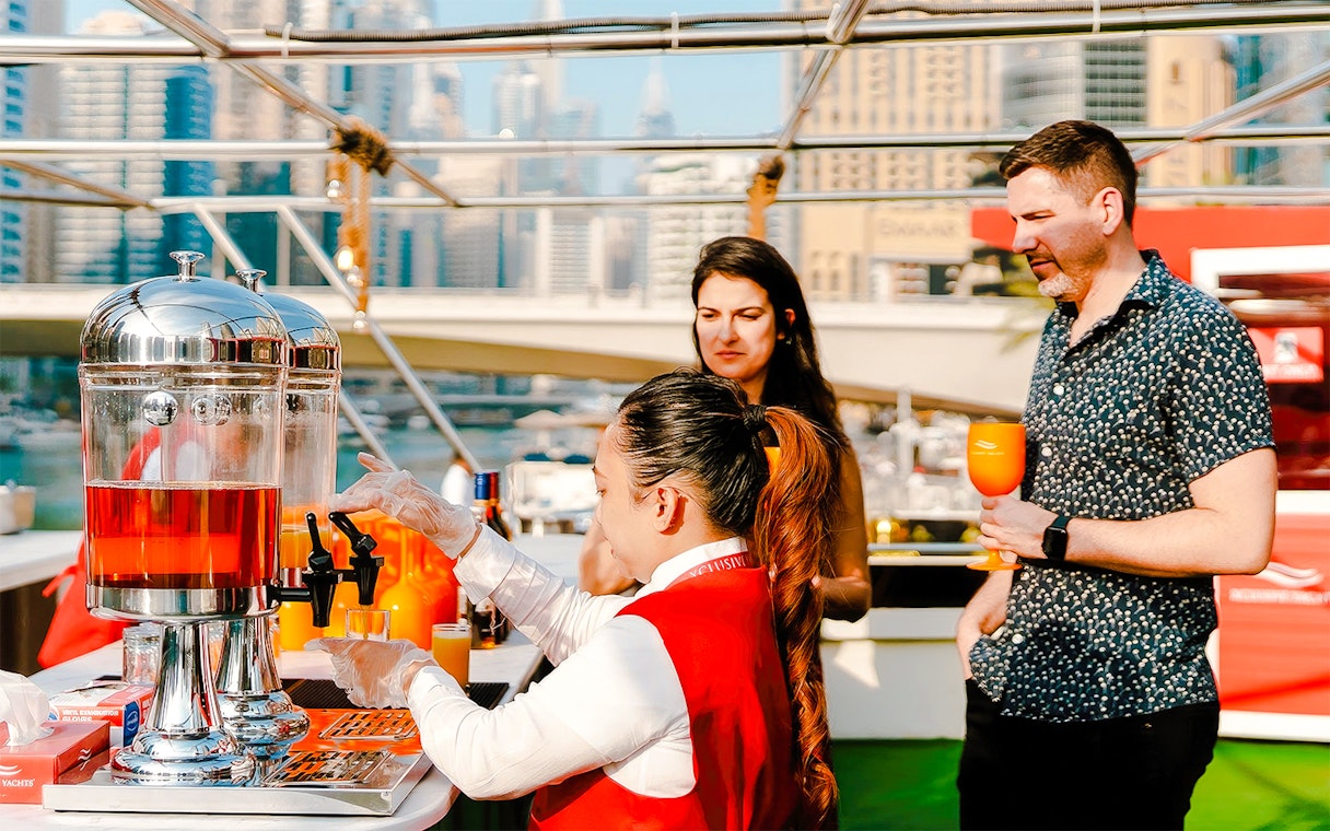 Visitors enjoying drinks on a Dubai Marina sunset cruise.
