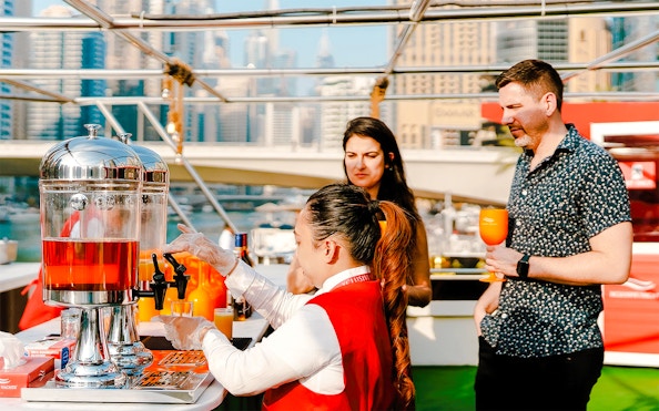 Visitors enjoying drinks on a Dubai Marina sunset cruise.