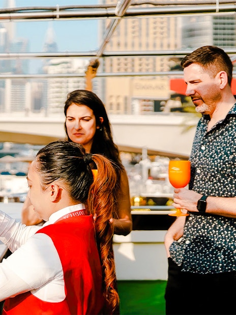 Visitors enjoying drinks on a Dubai Marina sunset cruise.