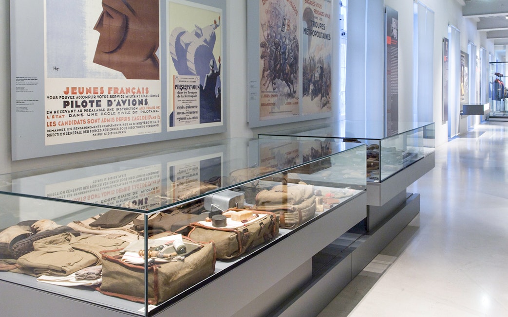 Display of military artifacts and vintage posters at Paris Army Museum exhibition.