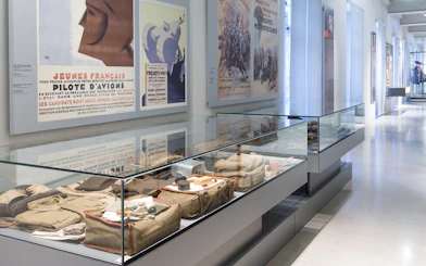 Display of military artifacts and vintage posters at Paris Army Museum exhibition.