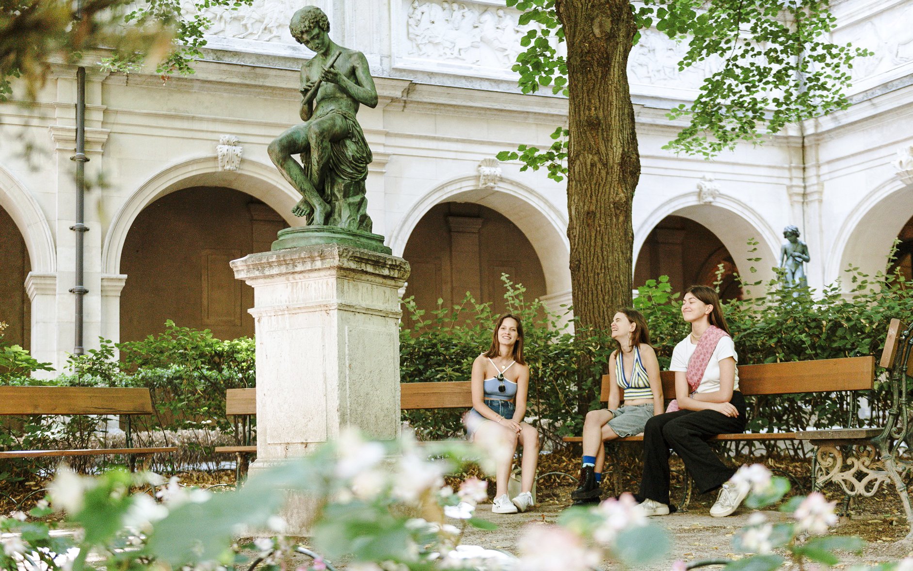 Visitors sitting near a statue in the courtyard of the Museum of Fine Arts, Lyon, France.